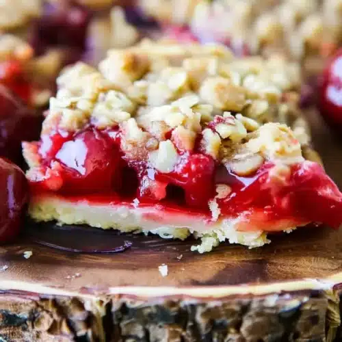 Cherry crisp bars mashup with juicy cherries and crunchy oat topping on wooden board