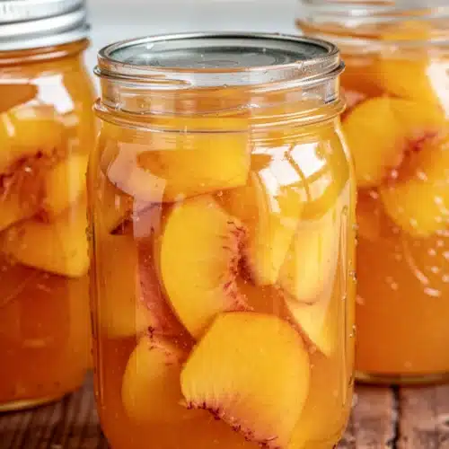 Jars of fresh peach jam with golden lids, glowing with summer sweetness