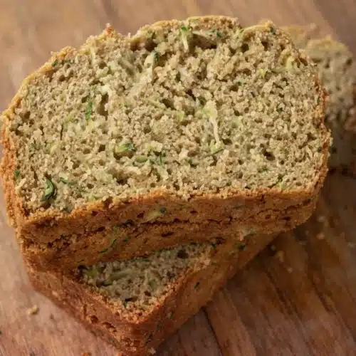 Moist gluten-free zucchini bread slices on wooden board