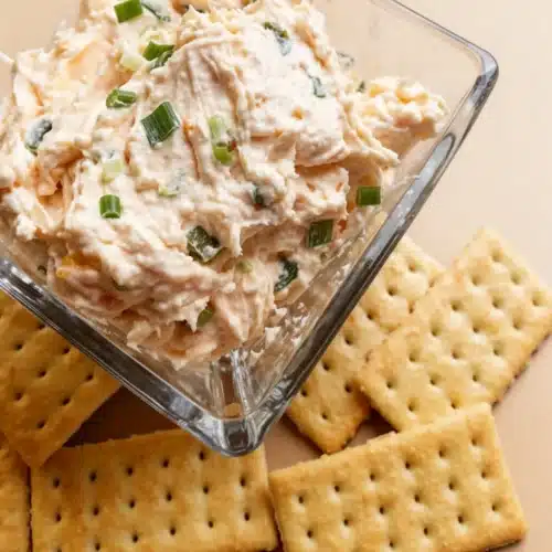 Jalapeno peach dip in a glass bowl with crackers