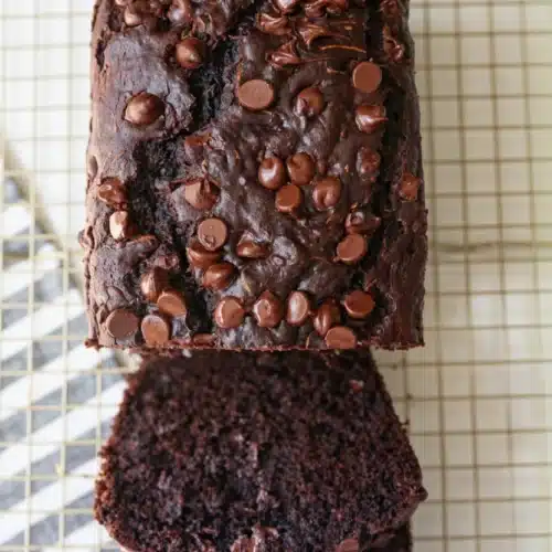 One bowl chocolate zucchini bread with chocolate chips on a cooling rack