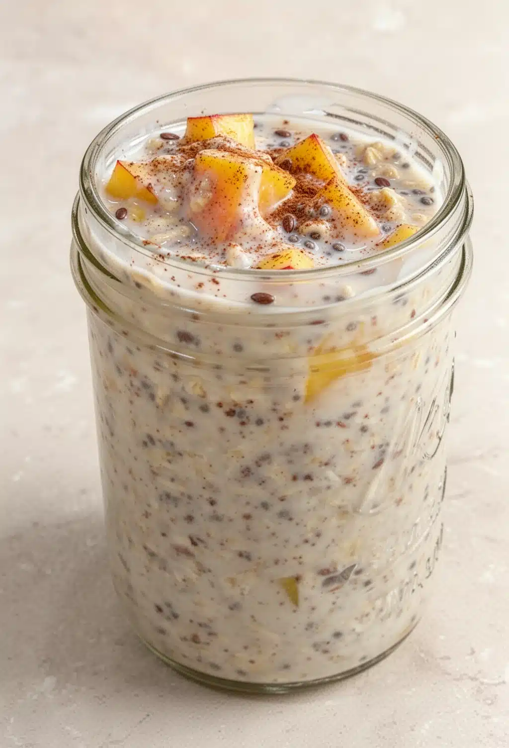 Overnight peach cobbler oatmeal in a jar with peaches and cinnamon