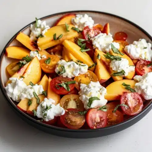 Peach burrata salad with champagne vinaigrette, fresh peaches, tomatoes, and basil