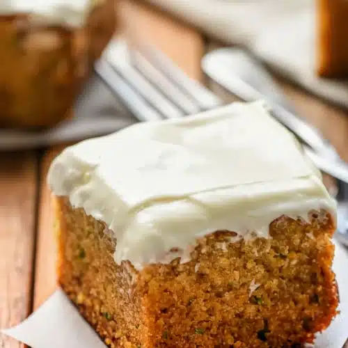 Perfect zucchini cake with cream cheese frosting on wooden table