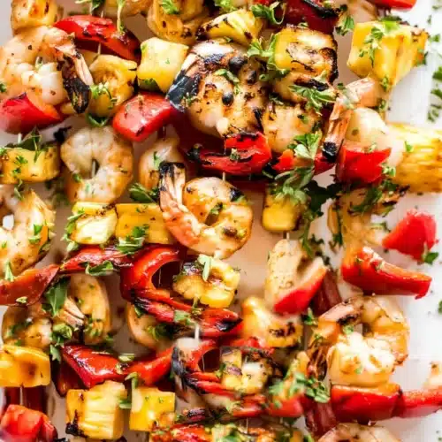 Grilled pineapple shrimp skewers with red peppers and herbs, perfect for BBQ