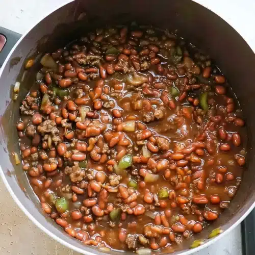Savory Baked Beans with Ground Beef: A Comforting Delight 1 Savory baked beans with ground beef in a pot, featuring beans, beef, peppers, and onions.