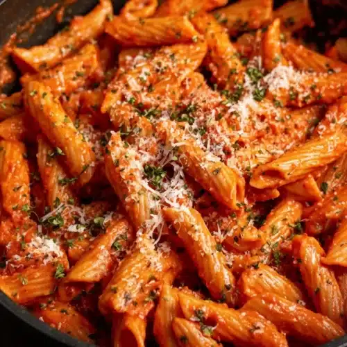 Simple red sauce pasta with Parmesan cheese and herbs in a skillet