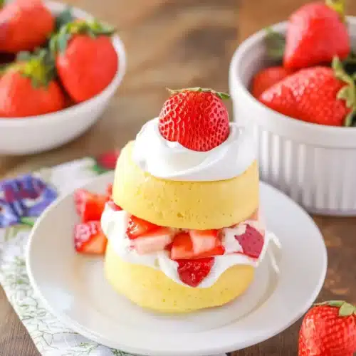 Strawberry shortcake with fresh strawberries and whipped cream on a white plate