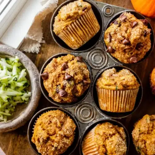 How to Make Pumpkin Zucchini Muffins: A Delightful Treat 1 Pumpkin zucchini muffins in a muffin tin with chocolate chips and shredded zucchini nearby